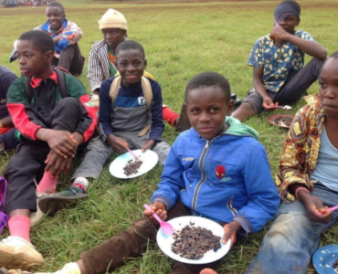 Students are eating food during lunch while sitting on the grass.