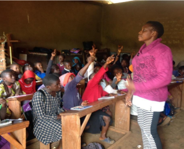 Students in a class are raising their hands.